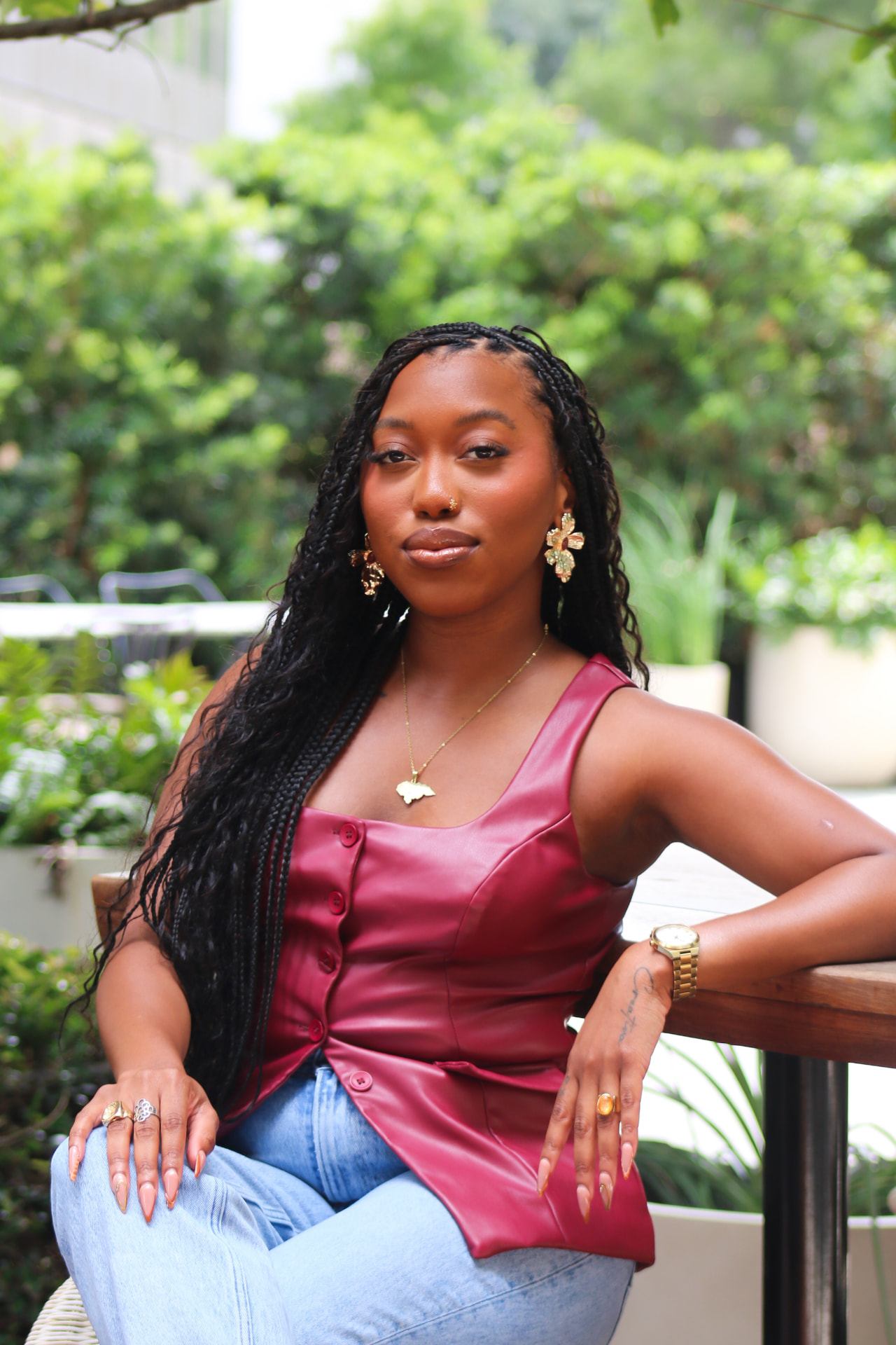 Portrait of Alexa, founder of Alexa Strategy Lab, outdoors in a burgundy leather top with gold jewelry